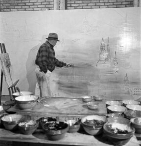 Photographie de Raoul Dufy, travaillant sur sa fresque "La Fée Electricité" dans son atelier en 1937.